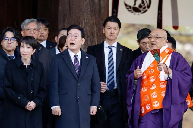Japan's Prime Minister Sanae Takaichi (L) and South Korea's President Lee Jae Myung (2nd L) listen to explanations from head priest Shokaku Furuya (R) as they visit the Western Precinct (Saiin Garan) at the Horyu-ji Temple in Ikaruga, Nara prefecture on January 14, 2026. (Photo by Franck ROBICHON / POOL / AFP)