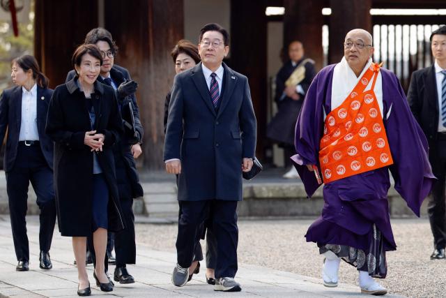Japan's Prime Minister Sanae Takaichi (L) and South Korea's President Lee Jae Myung (C) are escorted by head priest Shokaku Furuya (R) as they visit the Western Precinct (Saiin Garan) at the Horyu-ji Temple in Ikaruga, Nara prefecture on January 14, 2026. (Photo by Franck ROBICHON / POOL / AFP)