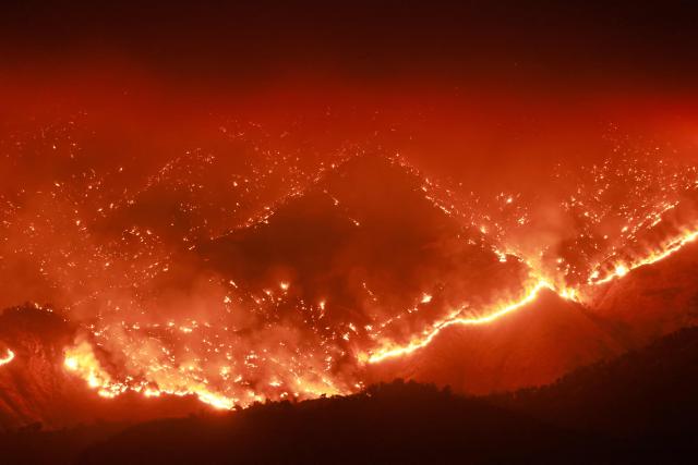 (FILES) (FILES) Embers glow at night as the Basin Fire burns in the Sierra National Forest in Fresno County, California, on June 26, 2024. The Copernicus Institute releases its report on world temperatures on January 14, 2026. (Photo by David SWANSON / AFP)