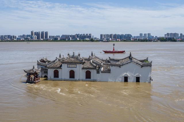 (FILES) The photo taken on July 6, 2024 shows an aerial view of a partially submerged Guanyin temple in floodwaters in the swollen Yangtze River, in Ezhou, in central China's Hubei province. The Copernicus Institute releases its report on world temperatures on January 14, 2026. (Photo by AFP) / China OUT