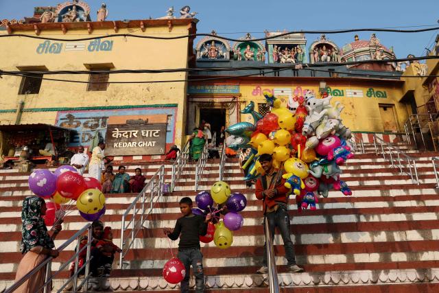 Balloon sellers wait for customers along the banks of river Ganges at Kedar Ghat in Varanasi on January 14, 2026. (Photo by Niharika KULKARNI / AFP)