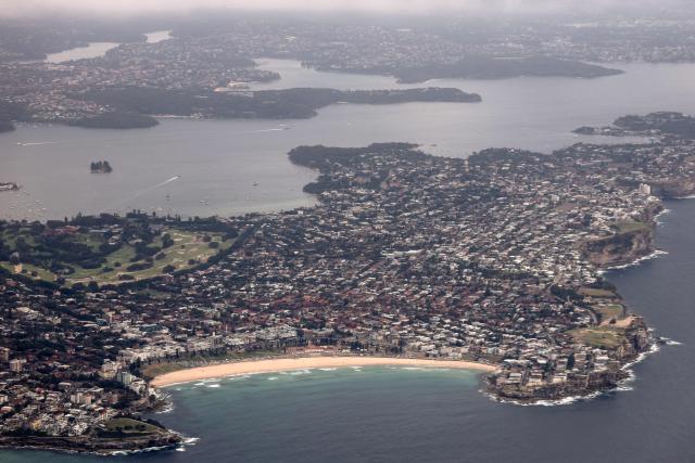 This photo shows an aerial view of Bondi Beach and Sydney Harbour as seen from a plane flying over Sydney on January 14, 2026. (Photo by DAVID GRAY / AFP)