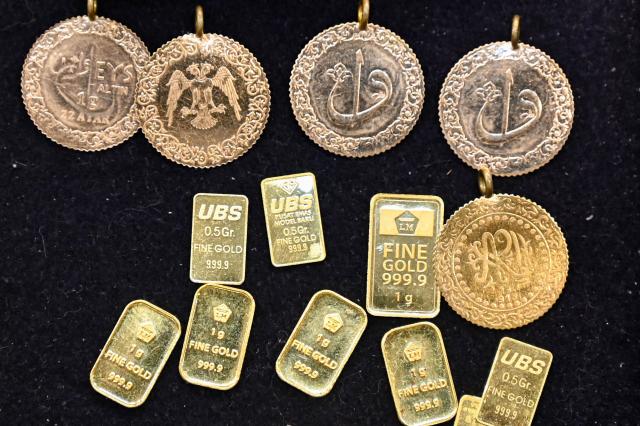 Gold coins and bullions are displayed at a jewellery store in Banda Aceh on January 14, 2026. (Photo by CHAIDEER MAHYUDDIN / AFP)