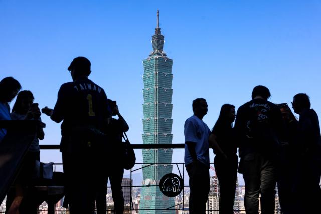 People gather at a lookout point as the landmark Taipei 101 building is seen in the background in Taipei on January 14, 2026. (Photo by I-Hwa Cheng / AFP)