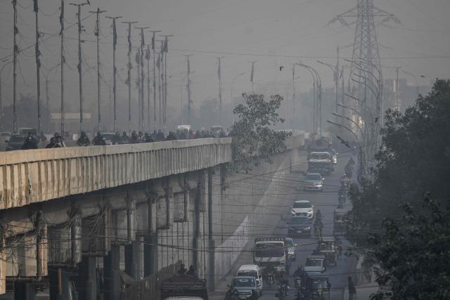 Commuters ride along a street amid foggy conditions in Karachi on January 14, 2026. (Photo by Rizwan TABASSUM / AFP)