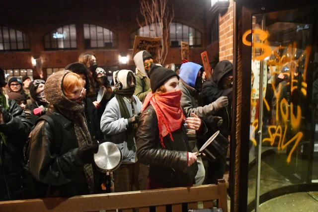 Anti-ICE demonstrators protest outside the graffiti tagged Graduate Hotel where federal immigration agents are believed to be staying in Minneapolis, Minnesota on January 13, 2026. Hundreds more federal agents were heading to Minneapolis, the US homeland security chief said on January 11, brushing aside demands by the Midwestern city's Democratic leaders to leave after an immigration officer fatally shot a woman protester. In multiple TV interviews, US Homeland Secretary Kristi Noem defended the actions of the officer who shot and killed 37-year-old Renee Nicole Good, whose death has sparked renewed protests nationwide against President Donald Trump's immigration crackdown. (Photo by Octavio JONES / AFP)