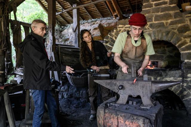Mylene Pardoen (L), researcher at the French National Center for Scientific Research (CNRS) and sound heritage archaeologist, captures the sounds of manual labor performed by the builders of Guedelon Castle, who are using 13th-century techniques and tools to construct a fortified castle in Treigny, central eastern France, on September 11, 2025. Mylene Pardoen, "sound archaeologist", captures the sounds of a fortified castle under construction using 13th-century techniques to recreate the soundtrack of the Middle Ages. This former military helicopter mechanic has retrained as a musicologist. Combining her passion for history with her expertise in sound, she has invented her own profession, unique in the world: "sound archaeologist". (Photo by ARNAUD FINISTRE / AFP)