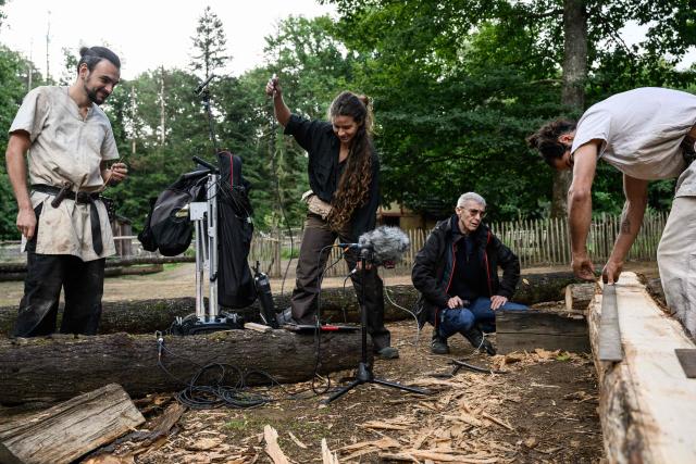 Mylene Pardoen (2ndR), researcher at the French National Center for Scientific Research (CNRS) and sound heritage archaeologist, captures the sounds of manual labor performed by the builders of Guedelon Castle, who are using 13th-century techniques and tools to construct a fortified castle in Treigny, central eastern France, on September 11, 2025. Mylene Pardoen, "sound archaeologist", captures the sounds of a fortified castle under construction using 13th-century techniques to recreate the soundtrack of the Middle Ages. This former military helicopter mechanic has retrained as a musicologist. Combining her passion for history with her expertise in sound, she has invented her own profession, unique in the world: "sound archaeologist". (Photo by ARNAUD FINISTRE / AFP)