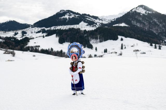 A 'Schoene' (Beautiful) costumed member of the yodel group 'Spitzli Schueppel' takes part in the traditional 'Silvesterchlausen' (Saint Sylvester’s Day festivities) in Urnasch, eastern Switzerland, on January 13, 2026. Silvesterchlausen a traditional custom from the Swiss canton of Appenzell, features colorfully dressed figures organized in groups called 'Schuppel' who symbolically chase away the old year and welcome the new one by traveling from farmstead to farmstead to sing yodels and greet farmers. The tradition take place twice a year: on December 31 for the “New Silvester,” and again on January 13, following the old Julian calendar. (Photo by ENNIO LEANZA / AFP)