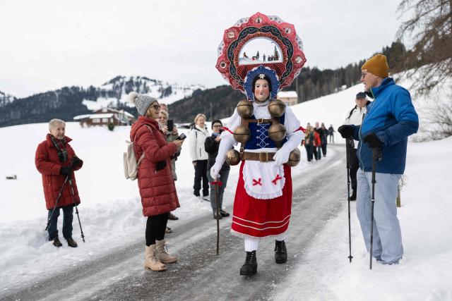 A 'Schoene' (Beautiful) costumed member of the yodel group 'Spitzli Schueppel' takes part in the traditional 'Silvesterchlausen' (Saint Sylvester’s Day festivities) in Urnasch, eastern Switzerland, on January 13, 2026. Silvesterchlausen a traditional custom from the Swiss canton of Appenzell, features colorfully dressed figures organized in groups called 'Schuppel' who symbolically chase away the old year and welcome the new one by traveling from farmstead to farmstead to sing yodels and greet farmers. The tradition take place twice a year: on December 31 for the “New Silvester,” and again on January 13, following the old Julian calendar. (Photo by ENNIO LEANZA / AFP)