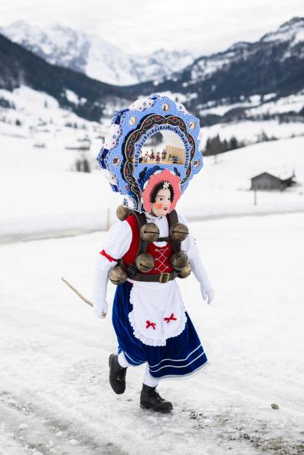A 'Schoene' (Beautiful) costumed member of the yodel group 'Spitzli Schueppel' takes part in the traditional 'Silvesterchlausen' (Saint Sylvester’s Day festivities) in Urnasch, eastern Switzerland, on January 13, 2026. Silvesterchlausen a traditional custom from the Swiss canton of Appenzell, features colorfully dressed figures organized in groups called 'Schuppel' who symbolically chase away the old year and welcome the new one by traveling from farmstead to farmstead to sing yodels and greet farmers. The tradition take place twice a year: on December 31 for the “New Silvester,” and again on January 13, following the old Julian calendar. (Photo by ENNIO LEANZA / AFP)