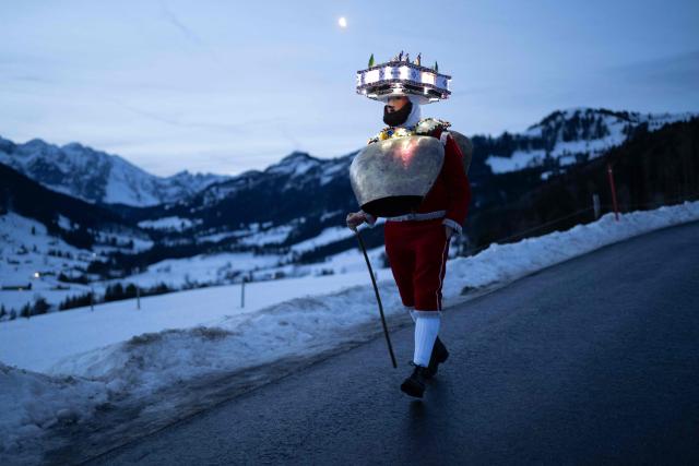 A 'Schoene' (Beautiful) costumed member of the yodel group 'Spitzli Schueppel' takes part in the traditional 'Silvesterchlausen' (Saint Sylvester’s Day festivities) in Urnasch, eastern Switzerland, on January 13, 2026. Silvesterchlausen a traditional custom from the Swiss canton of Appenzell, features colorfully dressed figures organized in groups called 'Schuppel' who symbolically chase away the old year and welcome the new one by traveling from farmstead to farmstead to sing yodels and greet farmers. The tradition take place twice a year: on December 31 for the “New Silvester,” and again on January 13, following the old Julian calendar. (Photo by ENNIO LEANZA / AFP)