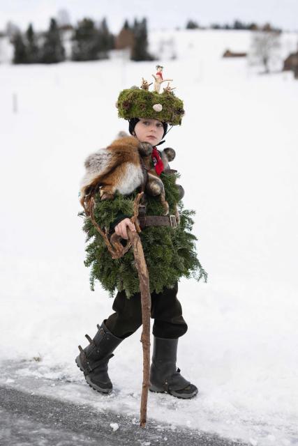 A young ‘Schoe-Wueeschten’ (‘Pretty-Ugly’) costumed members of a yodeling group takes part in the traditional 'Silvesterchlausen' (Saint Sylvester’s Day festivities) in Urnasch, eastern Switzerland, on January 13, 2026. Silvesterchlausen a traditional custom from the Swiss canton of Appenzell, features colorfully dressed figures organized in groups called 'Schuppel' who symbolically chase away the old year and welcome the new one by traveling from farmstead to farmstead to sing yodels and greet farmers. The tradition take place twice a year: on December 31 for the “New Silvester,” and again on January 13, following the old Julian calendar. (Photo by ENNIO LEANZA / AFP)