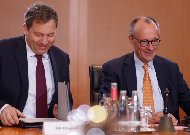 German Chancellor Friedrich Merz (R) and German Finance Minister and Vice Chancellor Lars Klingbeil talk at the start of the weekly cabinet meeting on January 14, 2026 at the Chancellery in Berlin. (Photo by Odd ANDERSEN / AFP)