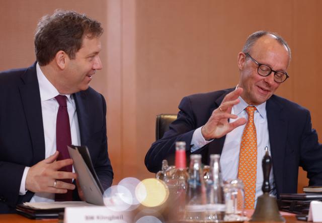 German Chancellor Friedrich Merz (R) and German Finance Minister and Vice Chancellor Lars Klingbeil talk at the start of the weekly cabinet meeting on January 14, 2026 at the Chancellery in Berlin. (Photo by Odd ANDERSEN / AFP)