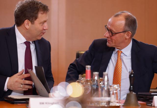 German Chancellor Friedrich Merz (R) and German Finance Minister and Vice Chancellor Lars Klingbeil talk at the start of the weekly cabinet meeting on January 14, 2026 at the Chancellery in Berlin. (Photo by Odd ANDERSEN / AFP)