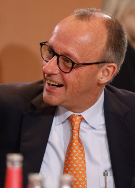 German Chancellor Friedrich Merzlaughs as he starts the weekly cabinet meeting on January 14, 2026 at the Chancellery in Berlin. (Photo by Odd ANDERSEN / AFP)