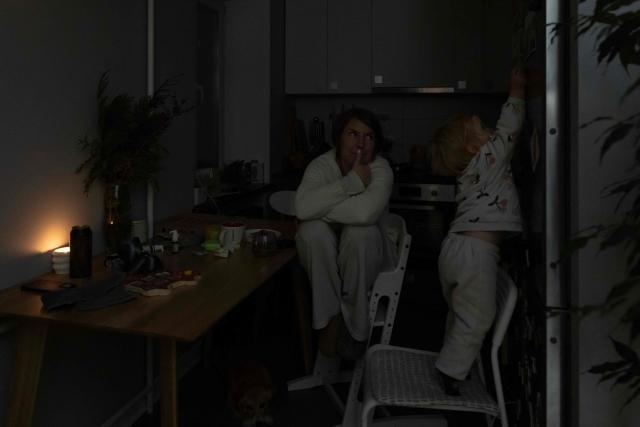 Local resident Kateryna watches her two-year-old daughter during a power outage at the family's apartment in Kyiv on January 13, 2026, amid the Russian invasion of Ukraine. (Photo by Andrew Kravchenko / AFP)