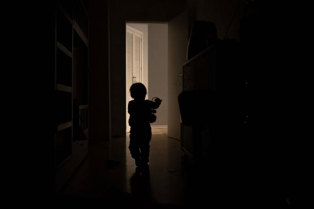 Two-year-old daughter of local residents Stas and Kateryna plays during a power outage at the family's apartment in Kyiv on January 13, 2026, amid the Russian invasion of Ukraine. (Photo by Andrew Kravchenko / AFP)