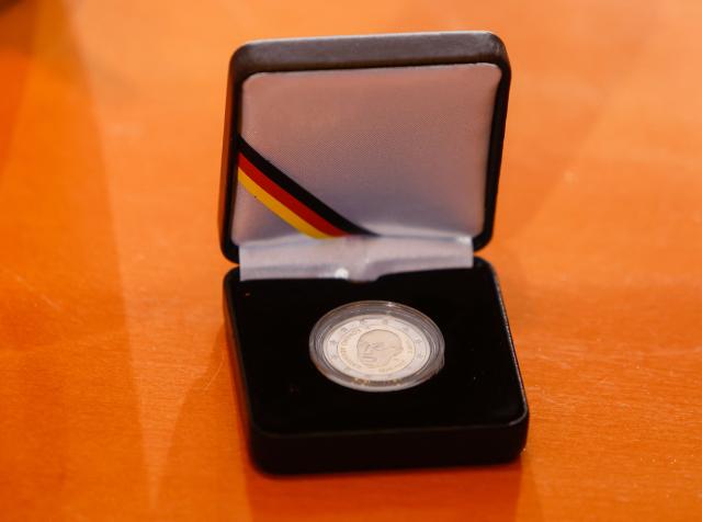 Close-up on a 2-Euro silver coin commemorating former and late German Chancellor Konrad Adenauer that was distributed to the cabinet members at the start of the weekly cabinet meeting on January 14, 2026 at the Chancellery in Berlin. The coin was officially released on January 8, 2026 on the occasion of the 150th birthday of late German Chancellor Konrad Adenauer (Photo by Odd ANDERSEN / AFP)
