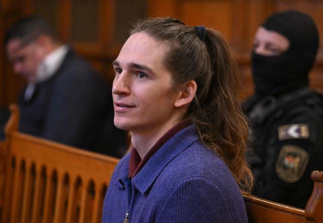 The defendant, German anti-fascist activist Maja T, sits in the courtroom in Budapest on January 14, 2026 to expect his verdict for allegedly participating in attacks against presumed neo-Nazis on the streets of the Hungarian capital. The case sparked uproar in Germany, with the country's top court saying the extradition order for the suspect, who identifies as non-binary, had failed to take into account potentially dangerous prison conditions in Hungary, especially for LGBTQ people. The defendant is accused of four counts of attempted assault as part of a criminal organisation aiming to "send a deterrent message to members of extreme-right movements" by "inflicting various life-threatening injuries" according to a court statement. (Photo by Attila KISBENEDEK / AFP) / EDITORS NOTE: ACCORDING TO COURT'S RULING THE FACES OF THE JUSTICE OFFICERS AND POLICE IN THE COURTROOM MUST BE MADE UNRECOGNIZABLE