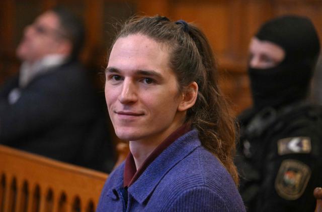 The defendant, German anti-fascist activist Maja T, sits in the courtroom in Budapest on January 14, 2026 to expect his verdict for allegedly participating in attacks against presumed neo-Nazis on the streets of the Hungarian capital. The case sparked uproar in Germany, with the country's top court saying the extradition order for the suspect, who identifies as non-binary, had failed to take into account potentially dangerous prison conditions in Hungary, especially for LGBTQ people. The defendant is accused of four counts of attempted assault as part of a criminal organisation aiming to "send a deterrent message to members of extreme-right movements" by "inflicting various life-threatening injuries" according to a court statement. (Photo by Attila KISBENEDEK / AFP) / EDITORS NOTE: ACCORDING TO COURT'S RULING THE FACES OF THE JUSTICE OFFICERS AND POLICE IN THE COURTROOM MUST BE MADE UNRECOGNIZABLE