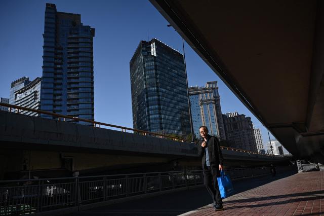 A man walks along a road in Hangzhou, in eastern China's Zhejiang province on January 14, 2026. (Photo by Jade GAO / AFP)