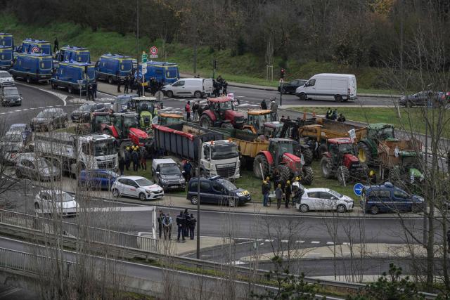 Farmers of the Coordination Rurale (CR) drive their tractors on a road outside Toulouse, southwestern France, in protest against the government's mandatory culling protocol for cattle herds affected by lumpy skin disease (dermatose nodulaire contagieuse) and the EU-Mercosur trade deal, on January 14, 2026. (Photo by Ed JONES / AFP)