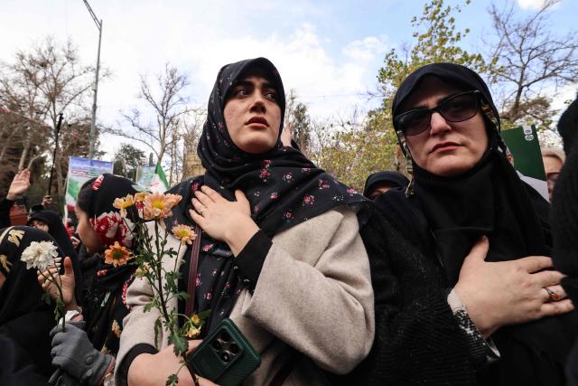 Iranian women mourn during the funerals of security forces personnel killed in recent protests in Tehran on January 14, 2026. A funeral ceremony began in Tehran on January 14, 2026 for over 100 members of the security forces and other "martyrs" killed in the wave of protests that has rocked the Islamic republic, state television said. (Photo by ATTA KENARE / AFP)