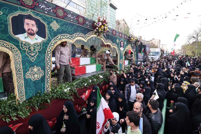 Iranians attend the funerals of security forces personnel killed in recent protests in Tehran on January 14, 2026. (Photo by ATTA KENARE / AFP)