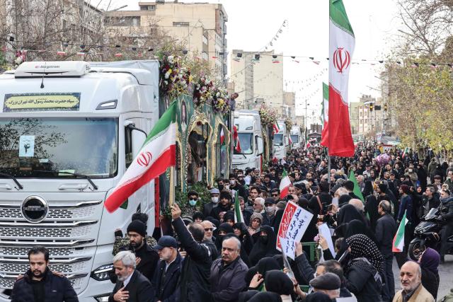Iranians attend the funerals of security forces personnel killed in recent protests in Tehran on January 14, 2026. A funeral ceremony began in Tehran on January 14, 2026 for over 100 members of the security forces and other "martyrs" killed in the wave of protests that has rocked the Islamic republic, state television said. (Photo by ATTA KENARE / AFP)