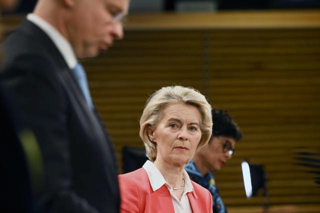 European Commission President Ursula von der Leyen (C) looks next to Commissioner for Enlargement Marta Kos (R) and Commissioner for Economy and Productivity, Implementation and Simplification Valdis Dombrovskis (L) speaks during a press conference to present a financial support package for Ukraine for 2026–2027 at the EU headquarters in Brussels on January 14, 2026. (Photo by Nicolas TUCAT / AFP)