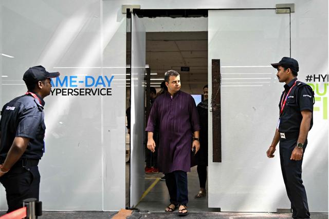 Indian entrepreneur Bhavish Aggarwal, co-founder and CEO of Ola (C), leaves an Ola Electric service centre during the rollout of the company’s 4680 Bharat Cell products in Bengaluru on January 14, 2026. (Photo by Idrees MOHAMMED / AFP)