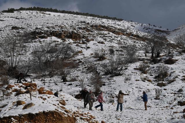People play in snow in the Syrian town of Bludan, some 50 kilometres northwest of the capital Damascus on January 14, 2026. (Photo by LOUAI BESHARA / AFP)