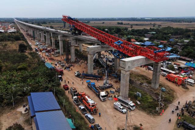 An aerial view of the wreckage of a train that crashed when a construction crane collapsed in Thailand's Nakhon Ratchasima province on January 14, 2026. A crane at a China-backed high-speed rail project in Thailand collapsed onto a passenger train on January 14 and caused it to derail, killing at least 32 people, authorities said. (Photo by Lillian SUWANRUMPHA / AFP)