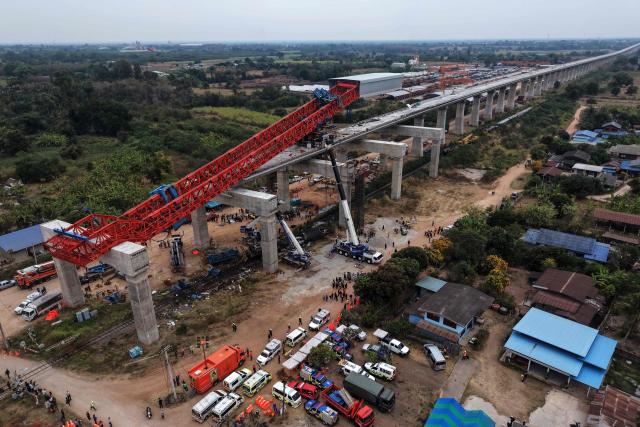 An aerial view of the wreckage of a train that crashed when a construction crane collapsed in Thailand's Nakhon Ratchasima province on January 14, 2026. A crane at a China-backed high-speed rail project in Thailand collapsed onto a passenger train on January 14 and caused it to derail, killing at least 32 people, authorities said. (Photo by Lillian SUWANRUMPHA / AFP)