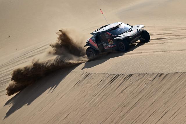 The Dacia Sandriders’s Qatari driver Nasser Al-Attiyah and Belgian co-pilot Fabian Lurquin compete in Stage 10 of the 48th edition of the Dakar Rally 2026, between Bisha and Bisha, Saudi Arabia, on January 14, 2026. (Photo by Giuseppe CACACE / AFP)