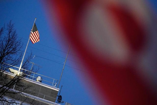 The US flag is seen on the roof of the US embassy, with the Greenlandic flag in the foreground during a demonstration under the motto "Greenland is for Greenlanders" in Copenhagen on January 14, 2026. Denmark will beef up its military presence in Greenland "from today", the defence ministry said, just before high-stakes talks were to start in Washington over US President Donald Trump's threats to take over the Arctic island. (Photo by Thomas Traasdahl / Ritzau Scanpix / AFP) / Denmark OUT