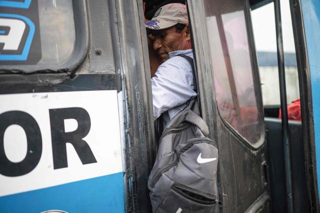 A man is inside a crowded bus during a strike called by public transport companies against extortion and to demand greater security in Lima on January 14, 2026.  (Photo by ERNESTO BENAVIDES / AFP)