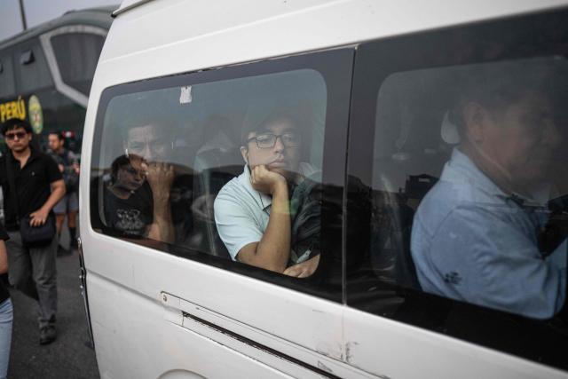 People crowd onto a bus during a strike called by public transport companies against extortion and to demand greater security in Lima on January 14, 2026.  (Photo by ERNESTO BENAVIDES / AFP)