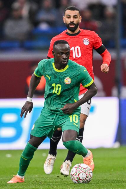 TOPSHOT - Senegal's forward #10 Sadio Mane outpasses Egypt's forward #10 Mohamed Salah during the Africa Cup of Nations (CAN) semi-final football match between Senegal and Egypt at the Grand stadium in Tangiers on January 14, 2026. (Photo by SEBASTIEN BOZON / AFP)