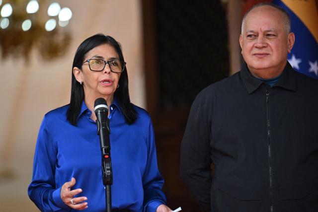 Venezuela's interim President Delcy Rodriguez (L) speaks next to Minister of the Popular Power for Interior Diosdado Cabello during a press conference at the Miraflores Presidential Palace in Caracas on January 14, 2026. Venezuela's interim president Delcy Rodriguez said on January 14, that her country was looking to "a new political era" after the January 3 ouster of leader Nicolas Maduro in a US military strike. (Photo by Juan BARRETO / AFP)