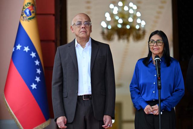 Venezuela's interim President Delcy Rodriguez (R) speaks next to President of the National Assembly Jorge Rodriguez  during a press conference at the Miraflores Presidential Palace in Caracas on January 14, 2026. Venezuela's interim president Delcy Rodriguez said on January 14, that her country was looking to "a new political era" after the January 3 ouster of leader Nicolas Maduro in a US military strike. (Photo by Juan BARRETO / AFP)