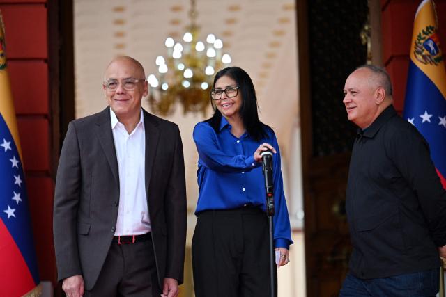Venezuela's interim President Delcy Rodriguez (C) gestures next to President of the National Assembly Jorge Rodriguez (L) and Minister of the Popular Power for Interior Diosdado Cabello during a press conference at the Miraflores Presidential Palace in Caracas on January 14, 2026. Venezuela has freed 15 journalists, including a leading opposition figure, as the slow release of political prisoners begun after Nicolas Maduro's ouster continues, activists said on January 14. (Photo by Juan BARRETO / AFP)