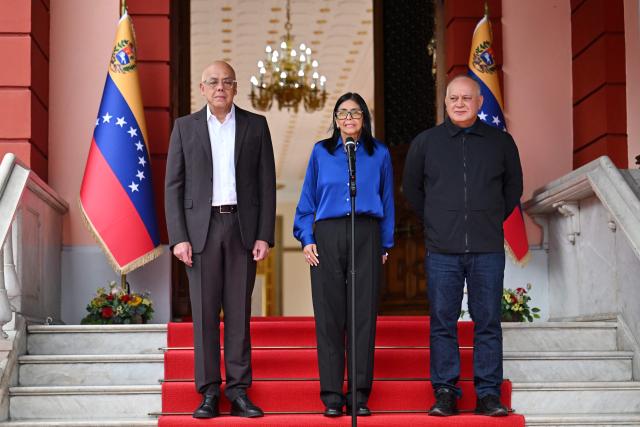 Venezuela's interim President Delcy Rodriguez (C) speaks next to President of the National Assembly Jorge Rodriguez (L) and Minister of the Popular Power for Interior Diosdado Cabello during a press conference at the Miraflores Presidential Palace in Caracas on January 14, 2026. Venezuela has freed 15 journalists, including a leading opposition figure, as the slow release of political prisoners begun after Nicolas Maduro's ouster continues, activists said on January 14. (Photo by Juan BARRETO / AFP)