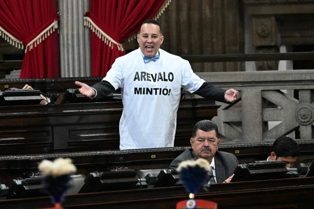 Carlos Calderon, a deputy from the VAMOS party, protests during the speech of Guatemala’s President Bernardo Arevalo as he delivers the official report of his second year as head of state at the National Congress in Guatemala City on January 14, 2026. (Photo by JOHAN ORDONEZ / AFP)