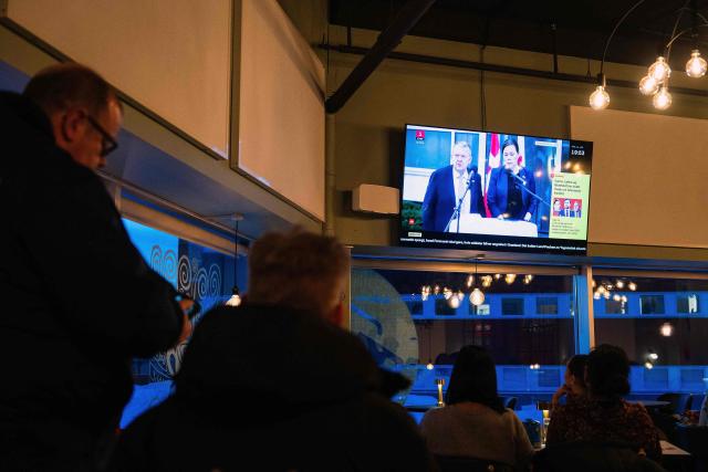 People watch a press conference of Greenland's Foreign Minister Vivian Motzfeldt and Denmark's Foreign Minister Lars Loekke Rasmussen on TV in a restaurant on January 14, 2026 in Nuuk, Greenland, after a meeting over the future of the island is being held in Washington. Independent UN experts on on January 14, 2026 expressed "grave concern" over US President Donald Trump's desire to take control of Greenland, a move they likened to "colonial domination". (Photo by Alessandro RAMPAZZO / AFP)