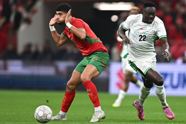 Morocco's defender #25 Adam Masina and Nigeria's forward #22 Akor Adams vie during the Africa Cup of Nations (CAN) semi-final football match between Nigeria and Morocco at the Prince Moulay Abdellah stadium in Rabat on January 14, 2026. (Photo by Paul ELLIS / AFP)