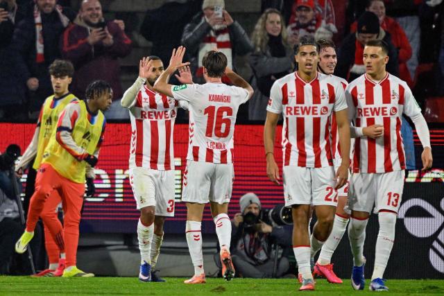 FC Cologne's German midfielder #37 Linton Maina celebrates scoring the opening goal with his teammates including FC Cologne's Polish midfielder #16 Jakub Kaminski (C) during the German first division Bundesliga football match between FC Cologne and FC Bayern Munich in Cologne, western Germany on January 14, 2026. (Photo by INA FASSBENDER / AFP) / DFL REGULATIONS PROHIBIT ANY USE OF PHOTOGRAPHS AS IMAGE SEQUENCES AND/OR QUASI-VIDEO