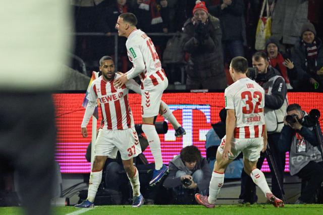 FC Cologne's German midfielder #37 Linton Maina (L) celebrates scoring the opening goal with his teammates FC Cologne's German midfielder #13 Said El Mala and FC Cologne's US defender #32 Kristoffer Lund during the German first division Bundesliga football match between FC Cologne and FC Bayern Munich in Cologne, western Germany on January 14, 2026. (Photo by INA FASSBENDER / AFP) / DFL REGULATIONS PROHIBIT ANY USE OF PHOTOGRAPHS AS IMAGE SEQUENCES AND/OR QUASI-VIDEO